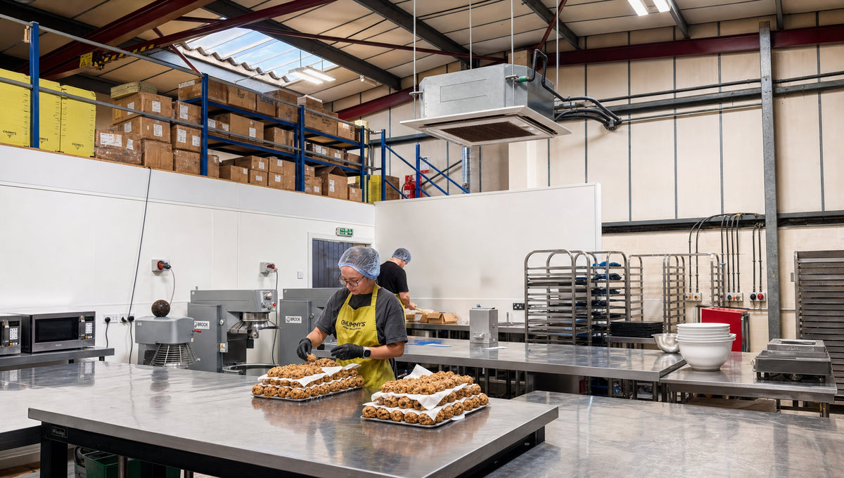 The bakery floor: trays of cookies on the bench, boxes stacked on the mezzanine