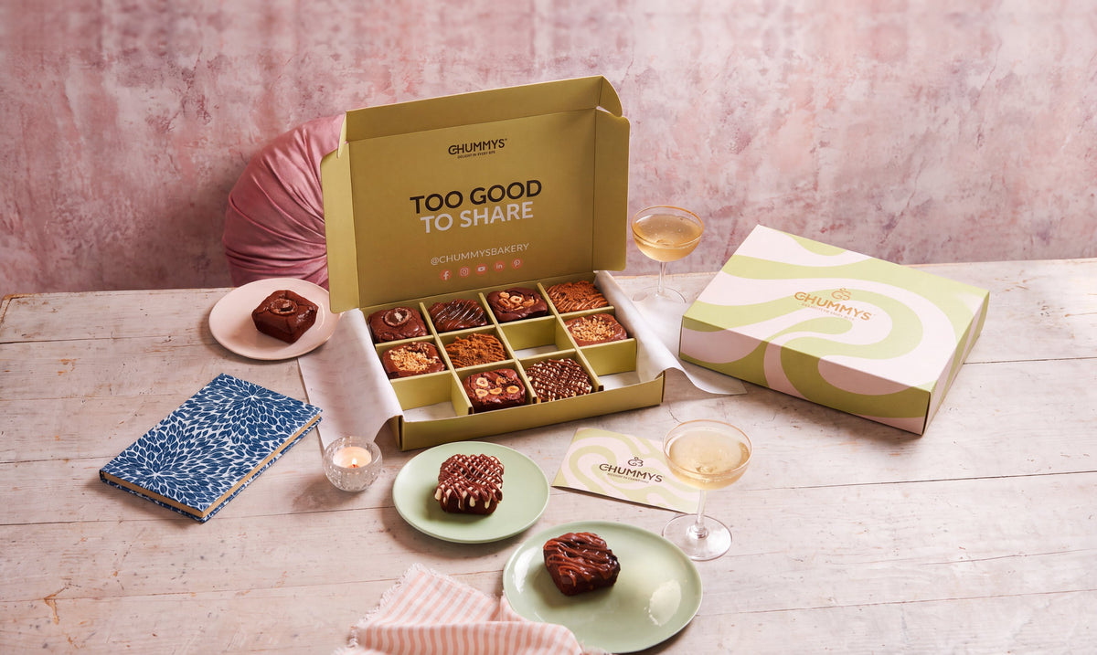 A box of twelve Chummys brownies open on the table beside the closed box